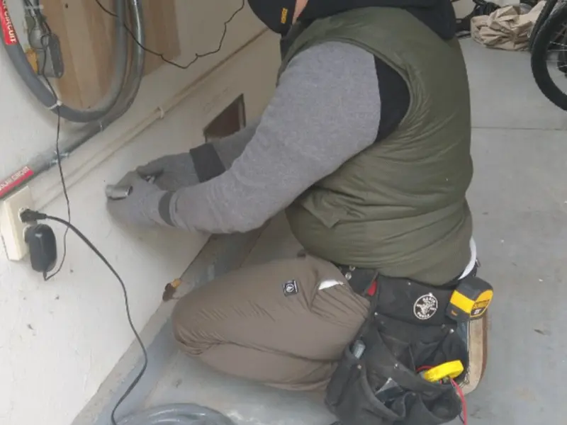 Electrician performing outlet wiring in a Bloomingdale garage